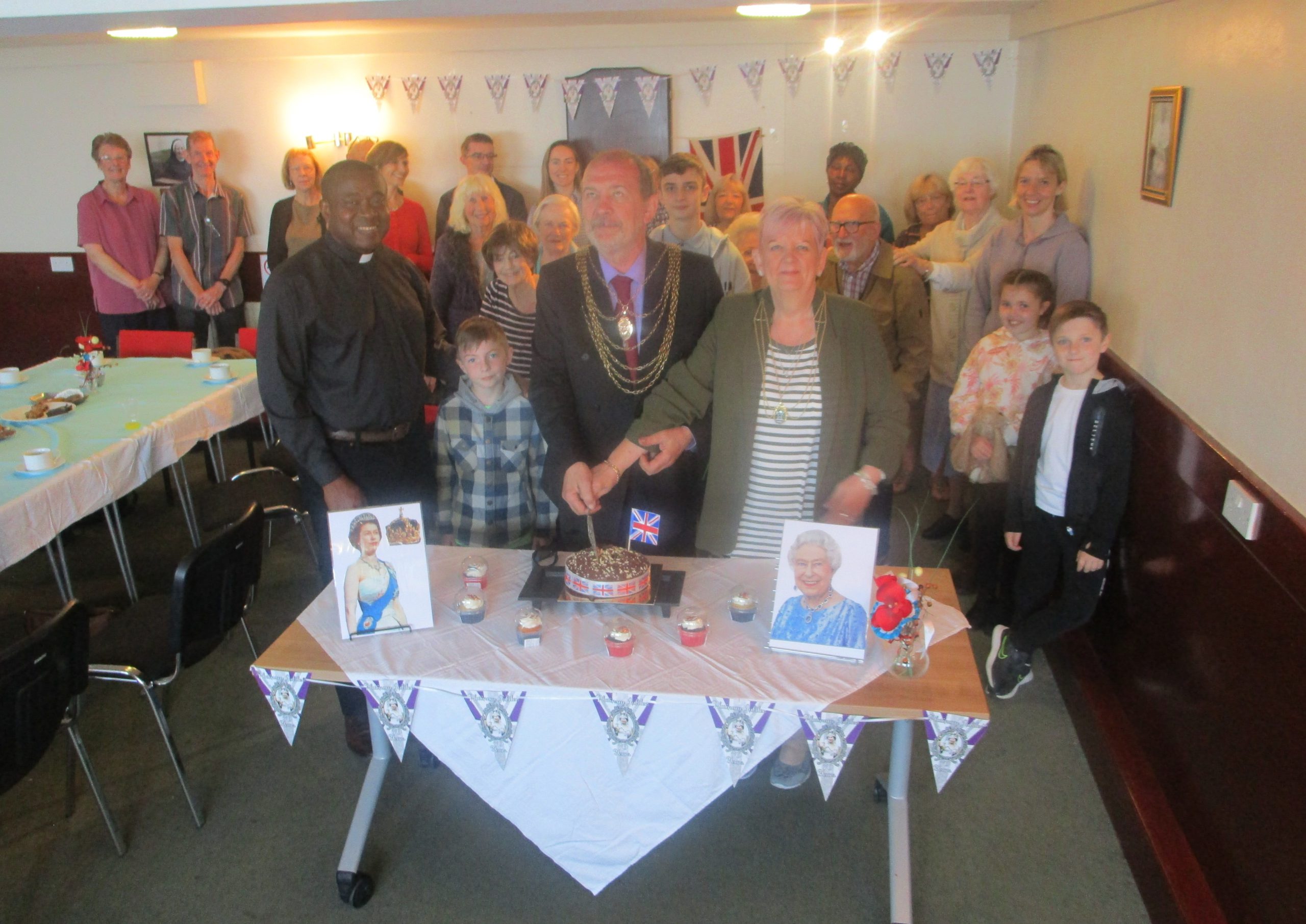 Councillor Ian Pearson, Civic Mayor of Doncaster, cutting the Platinum Jubilee cake pictured with Fr Desmond, Sue Pearson, Civic Mayoress of Doncaster, and parishioners.